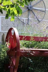 a red bench with a planter in front of a windmill at Casa da Aldeia da Avó in Valpaços