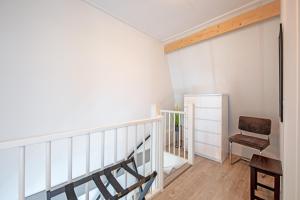 een kamer met een trap en een stoel bij Wulpenweid Bed & Parking in Den Burg