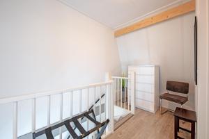 a room with a staircase and a chair at Wulpenweid Bed & Parking in Den Burg