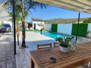 Un patio con una mesa y una piscina. en Chalet en Montellano (Sevilla), en Montellano