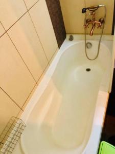 uma banheira branca com uma torneira na casa de banho em Joy City Stay Republicii 19 em Timişoara