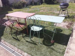 ein Picknicktisch, zwei Stühle und ein Grill in der Unterkunft CENT UN... 
