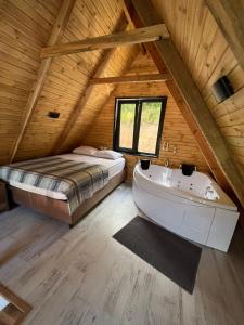 een slaapkamer met een bed en een bad op zolder bij Hidden Garden Bungalow in Trabzon