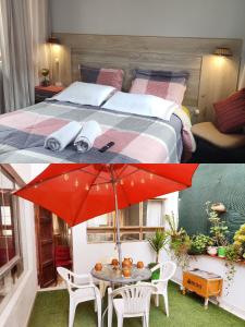 1 dormitorio con 1 cama y 1 mesa con sombrilla roja en Samayuna Wasi , entire apartment Cusco en Cuzco