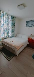 um quarto com uma cama grande e cortinas em Min Su Rooms em Stanwell