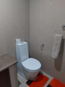 a bathroom with a white toilet and a sink at The Sails in Durban