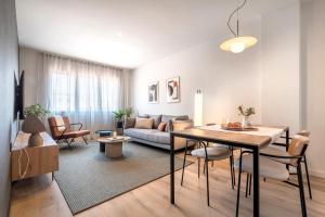 sala de estar con mesa y sofá en Arrivo Apartments, en Barcelona