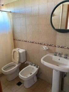 a bathroom with a toilet and a sink and a mirror at Departamento termal in Federación