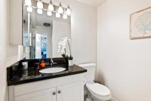 a bathroom with a sink and a toilet and a mirror at Sunset Haven 3-Bedrooms 2-Baths in Los Angeles