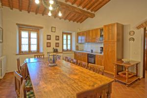 uma grande cozinha com uma mesa de madeira num quarto em Querciolaia by PosarelliVillas em Pieve a Presciano