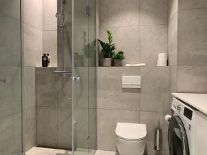 a bathroom with a toilet and a glass shower at Orange Apartments Tower & Free Parking in Tallinn