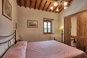 um quarto com uma cama e uma janela em Querciolaia by PosarelliVillas em Pieve a Presciano