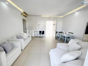 uma sala de estar com dois sofás brancos e uma mesa em Appartement cerise S+2 em Nabeul