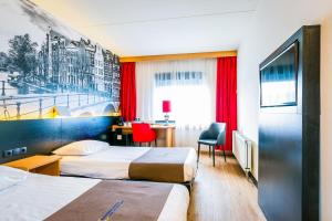 a hotel room with two beds and a desk at Bastion Hotel Amsterdam Amstel in Amsterdam