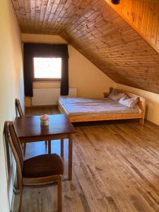 Cette chambre comprend un lit, une table et une fenêtre. dans l'établissement Kancsal Harcsa Panzió és Halászcsárda, à Tiszatelek