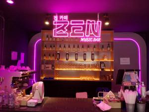 een bar met een neonbord in een kamer bij Thezen Hotel in Yasothon