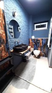 a blue bathroom with a sink and a toilet at Mogosoaia High Living Penthouse in Chitila +20 photos
