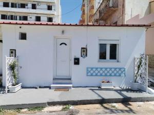 a white house with a white door at Blue central apt 10 min to the port/ wash machine in Lávrion
