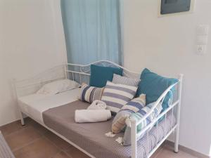 a baby bed with pillows and a blanket at Blue central apt 10 min to the port/ wash machine in Lavrio