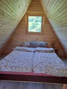 Bett in einem Holzzimmer mit Fenster in der Unterkunft Ozy's place in Kamnik