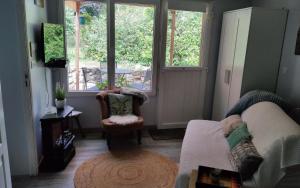 a living room with a couch and a window at Petit cottage in Saint-Pierre-la-Garenne