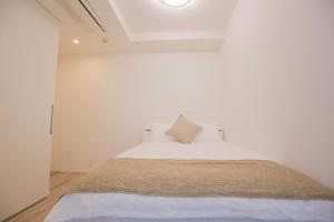 a bedroom with a white bed with a pillow on it at 3min walk to Kitasendo sta.-DYLYL in Tokyo
