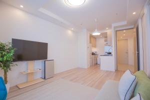 a living room with a flat screen tv on a wall at 3min walk to Kitasendo sta.-DYLYL in Tokyo
