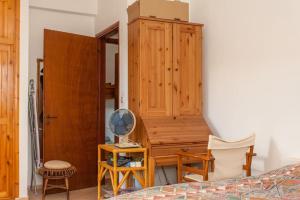 sypialnia z biurkiem, szafką i wentylatorem w obiekcie LESKA APARTMENT IN ARGYROUPOLI w mieście Arjirupoli