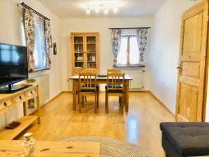 a living room with a table and chairs and a television at Haus Gerda Ferienwohnung 2 in Arnbruck