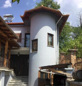 a white house with a balcony and stairs at Vila Tradicionale Violeta Korce in Korçë