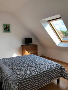 1 dormitorio con cama y ventana en Maison familiale à 1km de la mer, en Blainville-sur-Mer