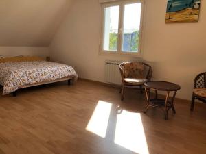 1 dormitorio con 1 cama, mesa y sillas en Maison familiale à 1km de la mer, en Blainville-sur-Mer