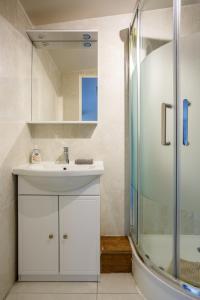 a white bathroom with a sink and a shower at Le blanc 23D 1ère ETG F2 duplex face gauche in Le Blanc-Mesnil