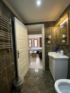 a bathroom with a sink and a toilet and a door at RİXOS PERA Apartment in Istanbul