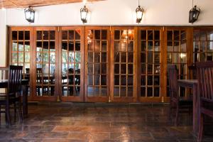 a dining room with wooden doors and windows at Zoete Rust Guesthouses in Lephalale
