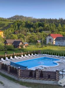 a swimming pool with lounge chairs and a resort at Zarichna Lyks in Slavske