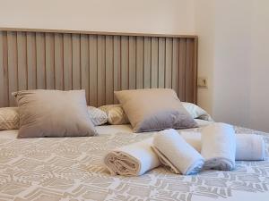 a bed with two pillows and towels on it at Allotjaments el Pont in Camprodon