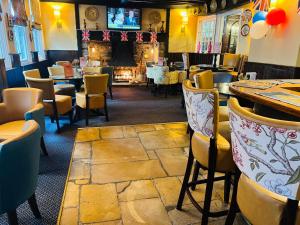 a restaurant with tables and chairs and a fireplace at Crown & Cushion Hotel in Chipping Norton