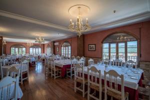 jadalnia z białymi stołami i krzesłami oraz żyrandolem w obiekcie Hotel Rural Spa Don Juan de Austria w mieście Jarandilla de la Vera +37 zdjęć