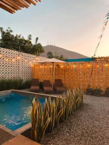 une arrière-cour avec une piscine et un mur en briques dans l'établissement Desert Lodges - La Terracota, à Ica
