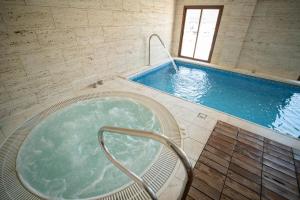 duży basen z jacuzzi w budynku w obiekcie Hotel Rural Spa Don Juan de Austria w mieście Jarandilla de la Vera