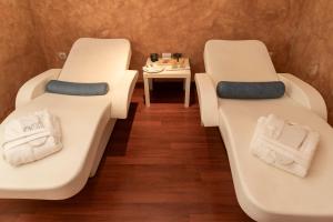 2 białe łóżka w pokoju ze stołem w obiekcie Hotel Rural Spa Don Juan de Austria w mieście Jarandilla de la Vera