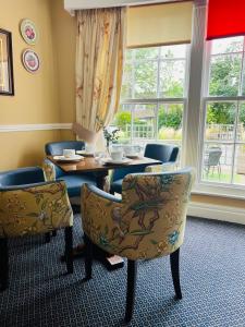 uma sala de jantar com cadeiras, uma mesa e uma janela em Crown & Cushion Hotel em Chipping Norton