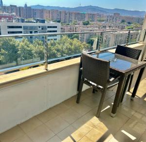 a table and chairs on a balcony with a view of a city at Espectacular piso cerca de la playa in Barcelona