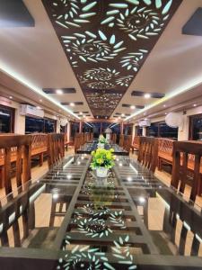 a long dining room with a long table and chairs at Kalappura Houseboats & Tours in Alleppey
