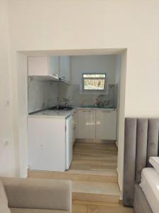 a kitchen with white cabinets and a white refrigerator at SOLE INN in Vlorë