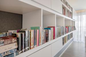 a row of white bookshelves filled with books at AlvorMar Apartamentos Turisticos in Alvor