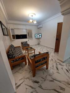 sala de estar con 2 mesas y suelo de baldosa en Appartement S2 Kantaoui vue mer en Port El Kantaoui