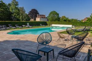 a group of chairs and a swimming pool at La Maison Cornière in Biéville-en-Auge