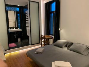 een slaapkamer met een bed en een badkamer met een wastafel bij Albert Molière in Brussel